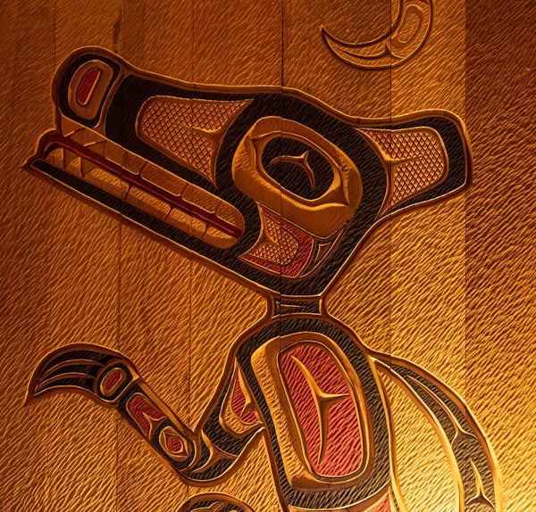 A wood carving of a bird on a wall